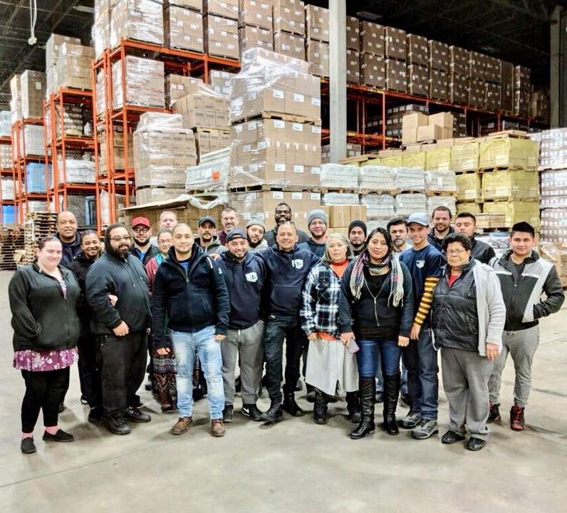 3G Warehouse team in front of stacked inventory at their fulfillment center, showcasing 3PL logistics and warehouse operations.