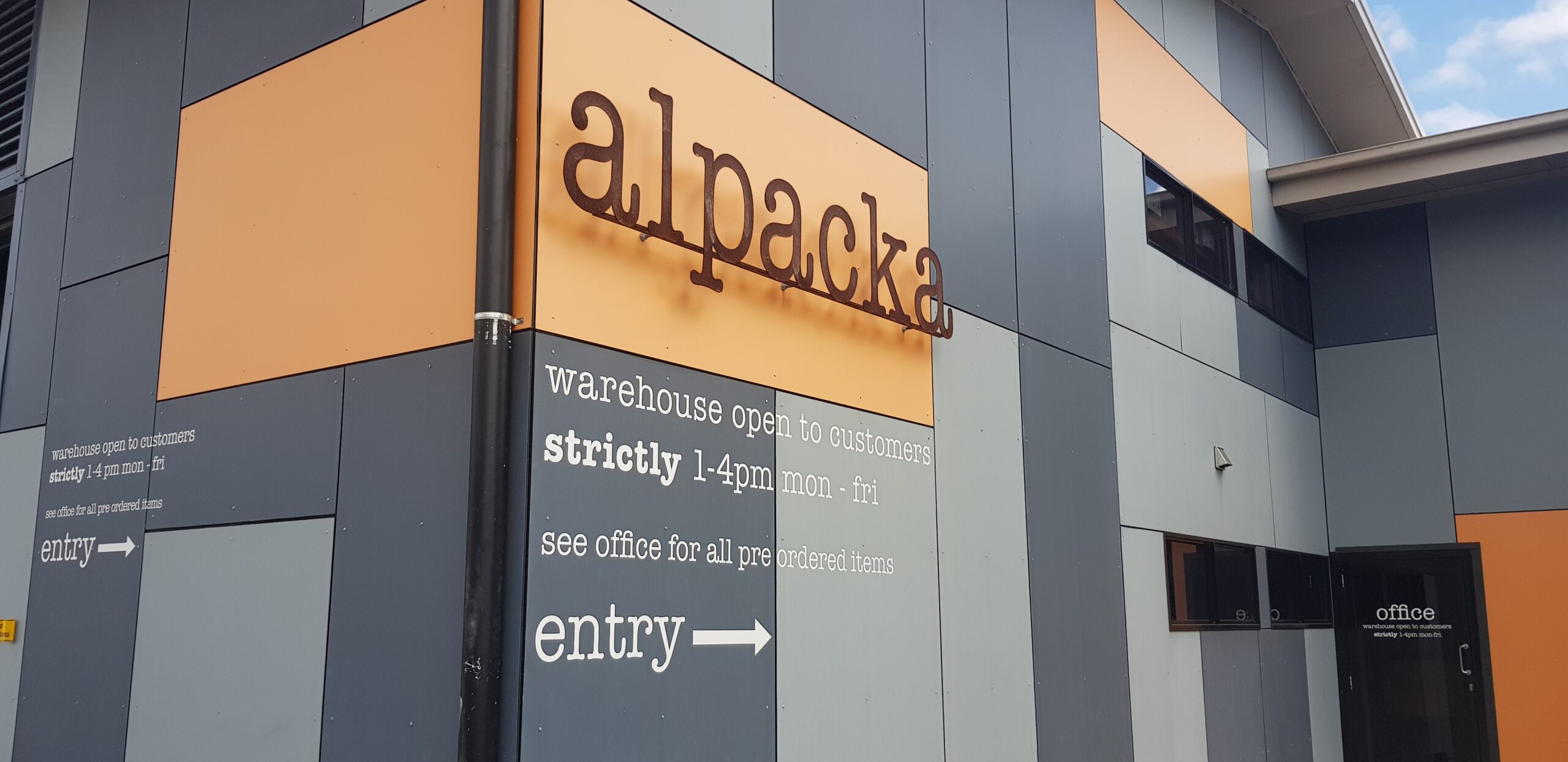 Exterior of Alpacka Fulfillment's San Jose, California warehouse, showing the company sign and customer entrance.