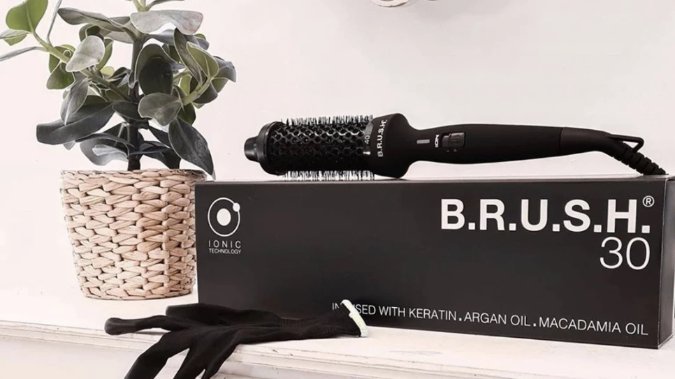 The B.R.U.S.H. 30/40 website features a clean, modern e-commerce design with a beauty-focused aesthetic. The main product image showcases a sleek hot styling brush tool, likely in black or dark colors, positioned prominently on the homepage. The site uses a minimalist layout with white backgrounds and professional product photography that highlights the brush's design and functionality. Additional product detail images demonstrate the brush's construction and oil-infusion features. The overall visual identity conveys professionalism and salon-quality results, with a focus on the product's premium ingredients like keratin, argan oil, and macadamia oil. The design emphasizes ease of use and professional results, targeting consumers who want salon-worthy hair styling at home. Customer reviews are prominently displayed, showing social proof, though the brand appears to be experiencing some quality concerns based on recent feedback.