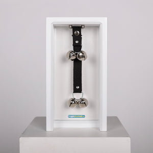 The Doggie Doorbell brand presents a clean, product-focused e-commerce design with a minimalist aesthetic. The homepage features a grid layout showcasing their main product in five color variants: Black, Blue, Gray, Camel, and Natural. Each product is displayed with high-quality photography against neutral backgrounds, emphasizing the doorbell's practical design and material quality. The visual identity appears understated and functional, matching the utilitarian nature of their pet accessory product. Product images show sleek, rectangular door-mounted devices in various earth tones and classic colors, suggesting durability and home décor compatibility. The overall design philosophy emphasizes simplicity and product clarity, with uniform pricing at $45.00 across all color options. The brand messaging focuses on problem-solving for pet owners, highlighting the protective benefits for doors and walls from pet scratching damage.